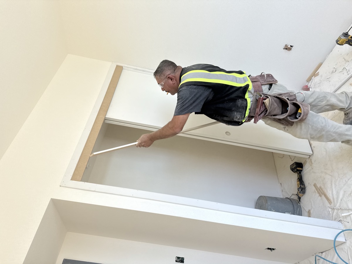 Technician fitting bypass closet doors and overhead track