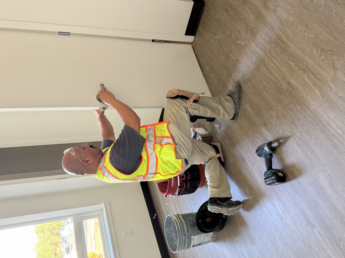 Monterey Bay Door technician fitting door hardware on a commercial jobsite