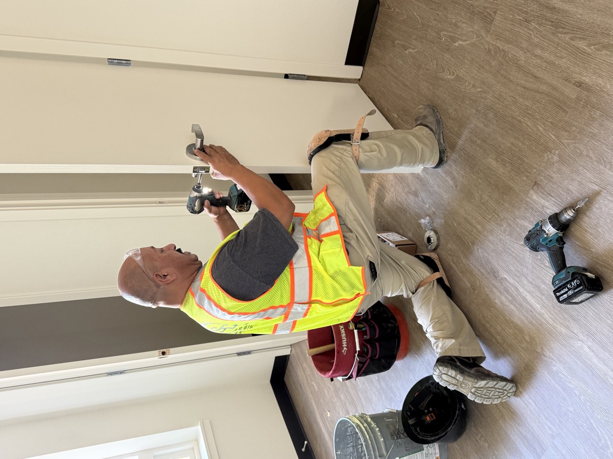 Technician installing a commercial lever lockset on a new door
