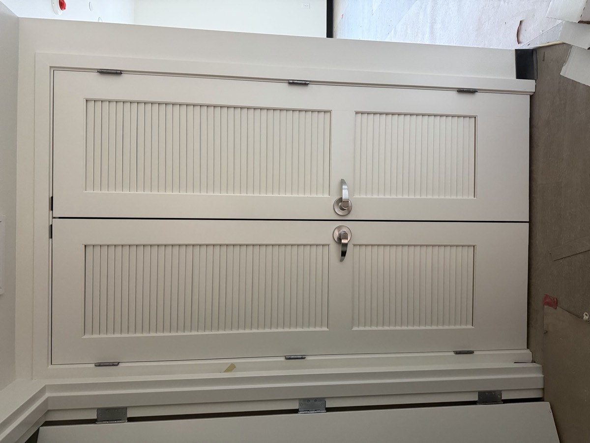 Louvered double doors with lever hardware installed in a mechanical closet